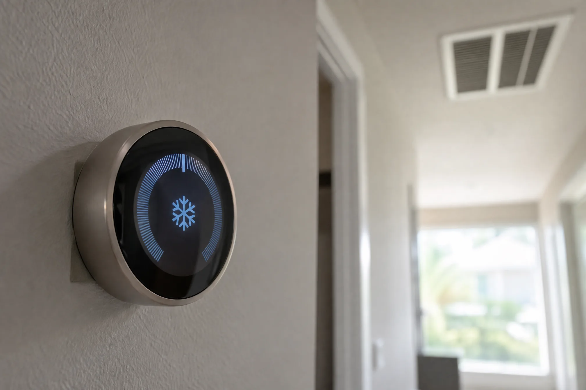 Close-up of a smart thermostat on a wall inside a Florida home showing a cooling cycle
