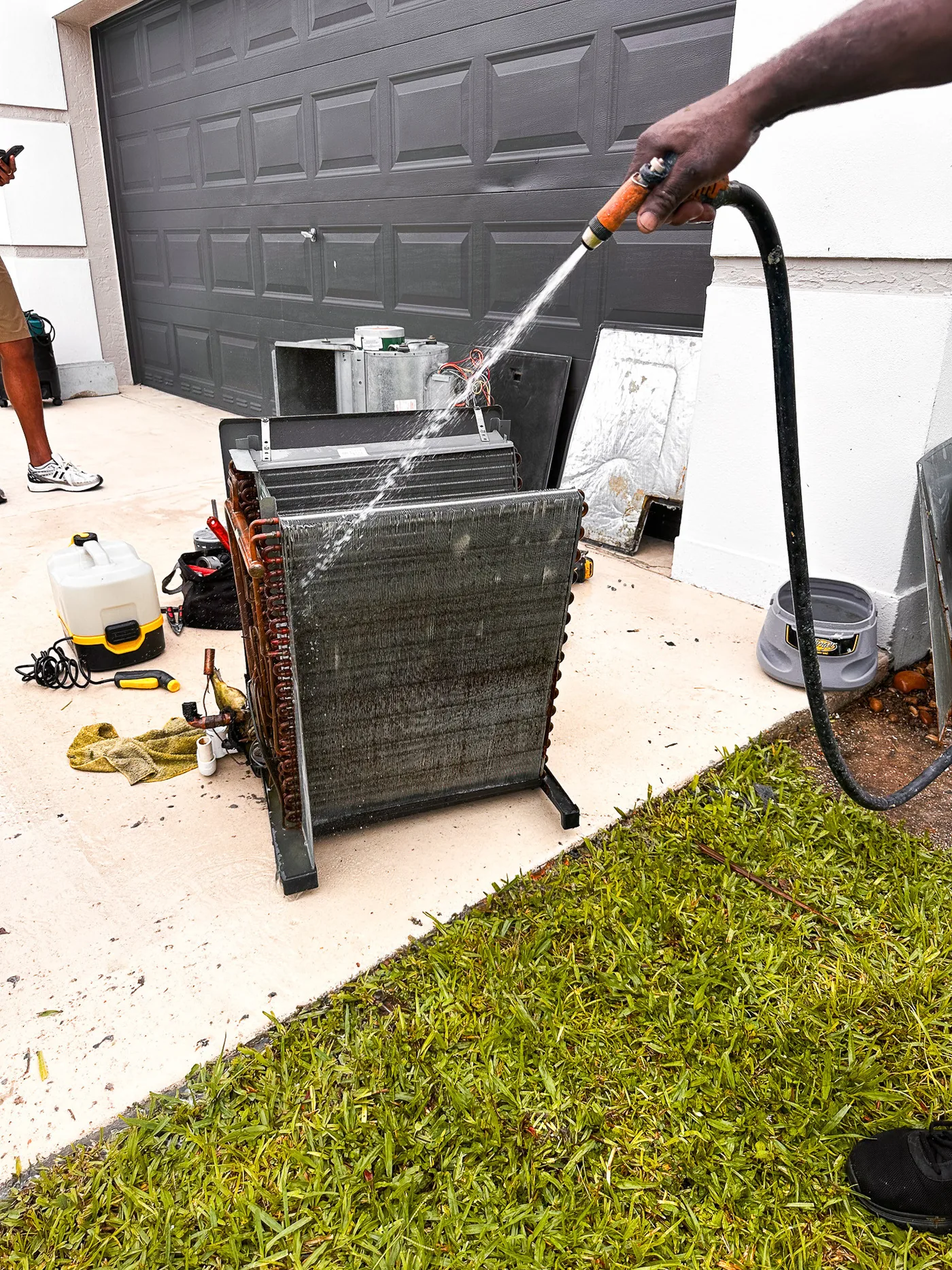 Two World Air HVAC technicians inspecting and servicing residential AC unit