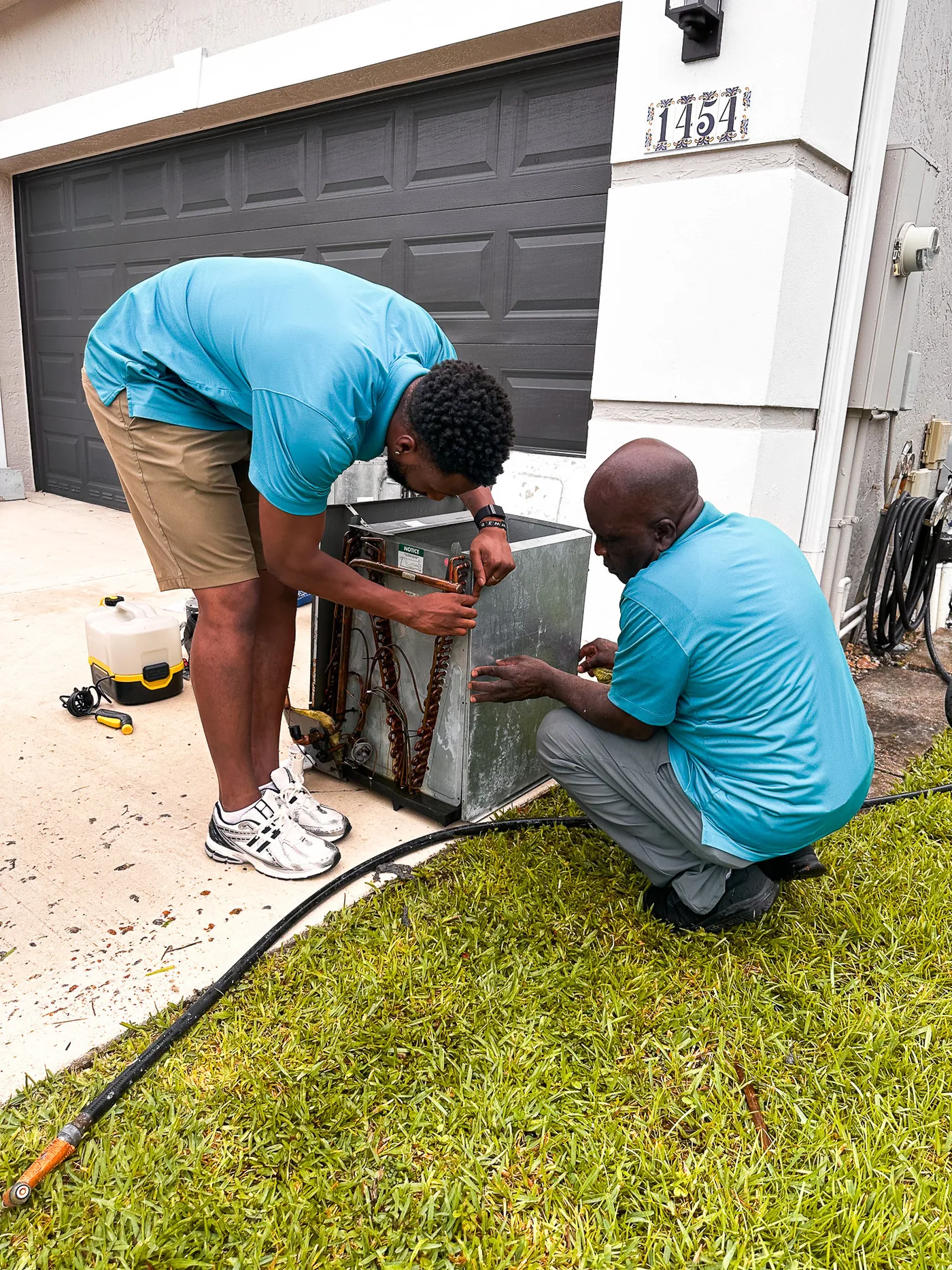 World Air HVAC technician checking refrigerant pressure with gauges on AC system